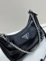 Prada Bags Batch 310 Lacquered Cowhide with Box Re－Edition NaplaK Prada Women's Shoulder or Crossbody Bag Size 22.5X18.5X7CM A bag that recreates the style grids 2005.Prada's design codes are condensed into versatile silhouettes, creating a dialogue between past present styles.Adjustable shoulder strap, parts, detachable key ring, exquisite simple leather item.The triangular logo of enamel metal exudes an iconic and charming design. - Image 4