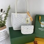 Goyard Bags 165 Goyard Bag is leather version of iconic Saint Louis bag, with Goyardine canvas lining.It offers two different aesthetic styles.Its gradually thickened handle provides a good grip comfortable feel.The compact and small form factor makes Anjou Mini perfect for nighttime use or carrying some daily essentials during the day. Style number: 98196 Color: White Size: 9cm x 19.5cm